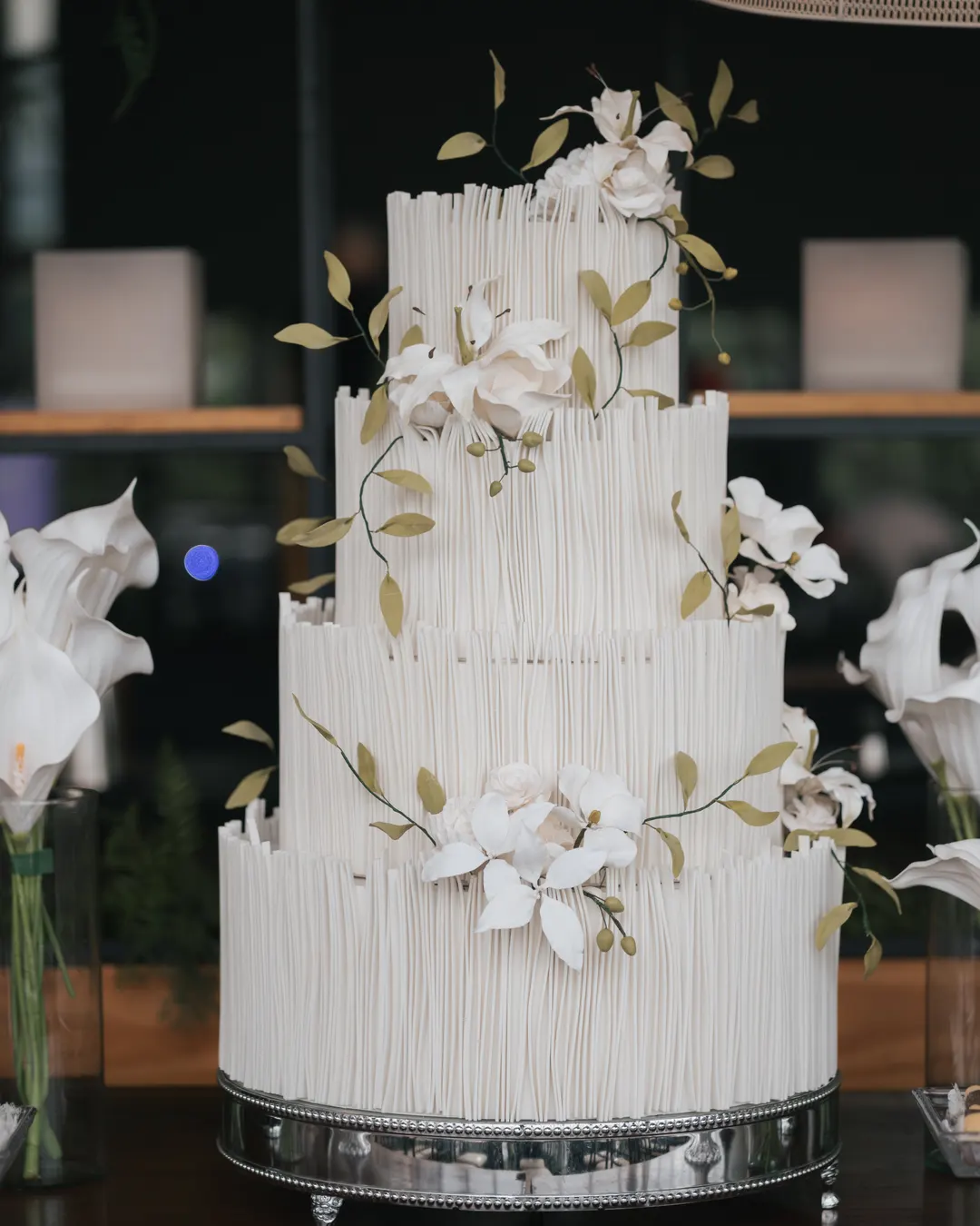 Bolo branco de quatro andares decorado com flores
