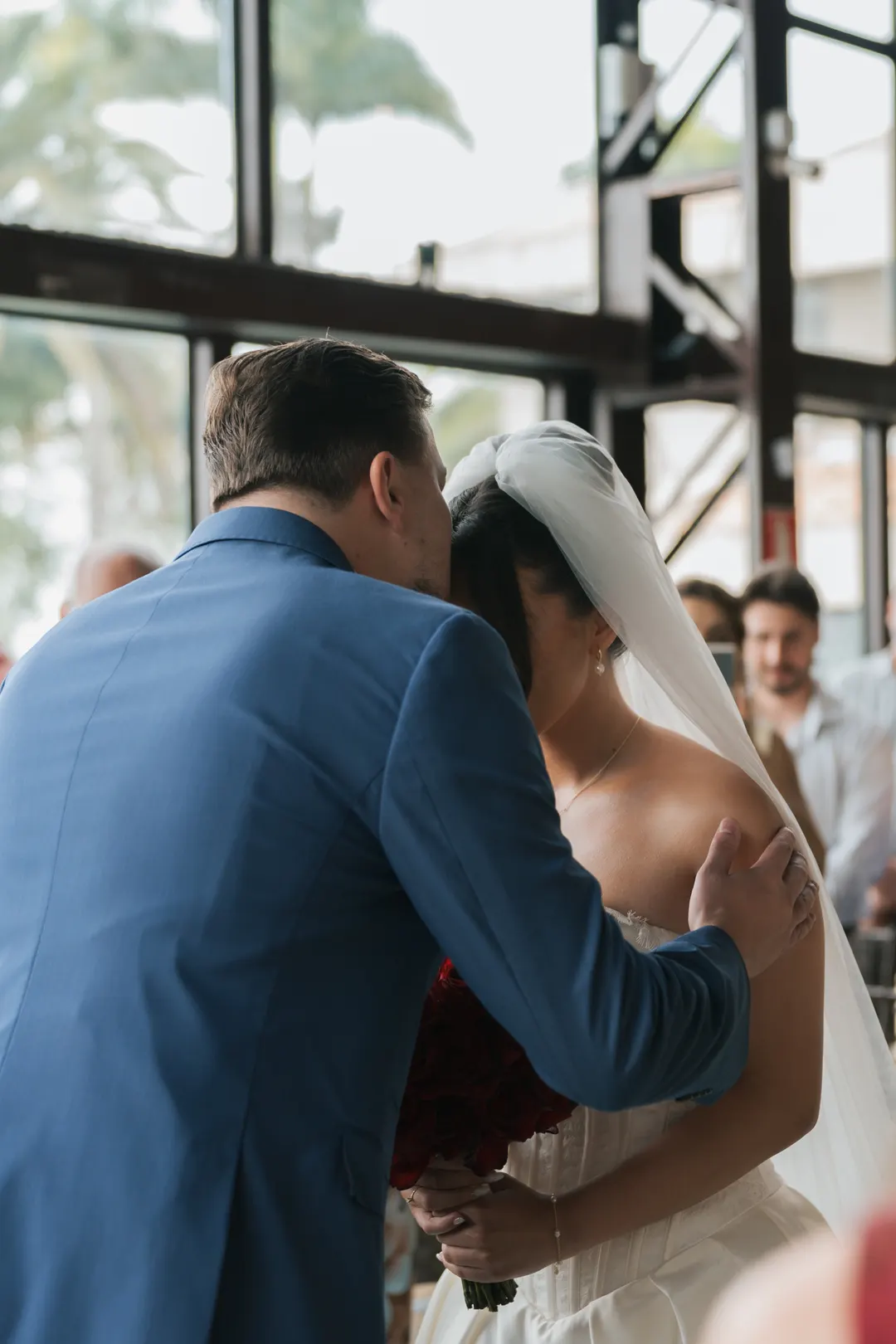 Pai da noiva beijando a filha na entrada da cerimônia