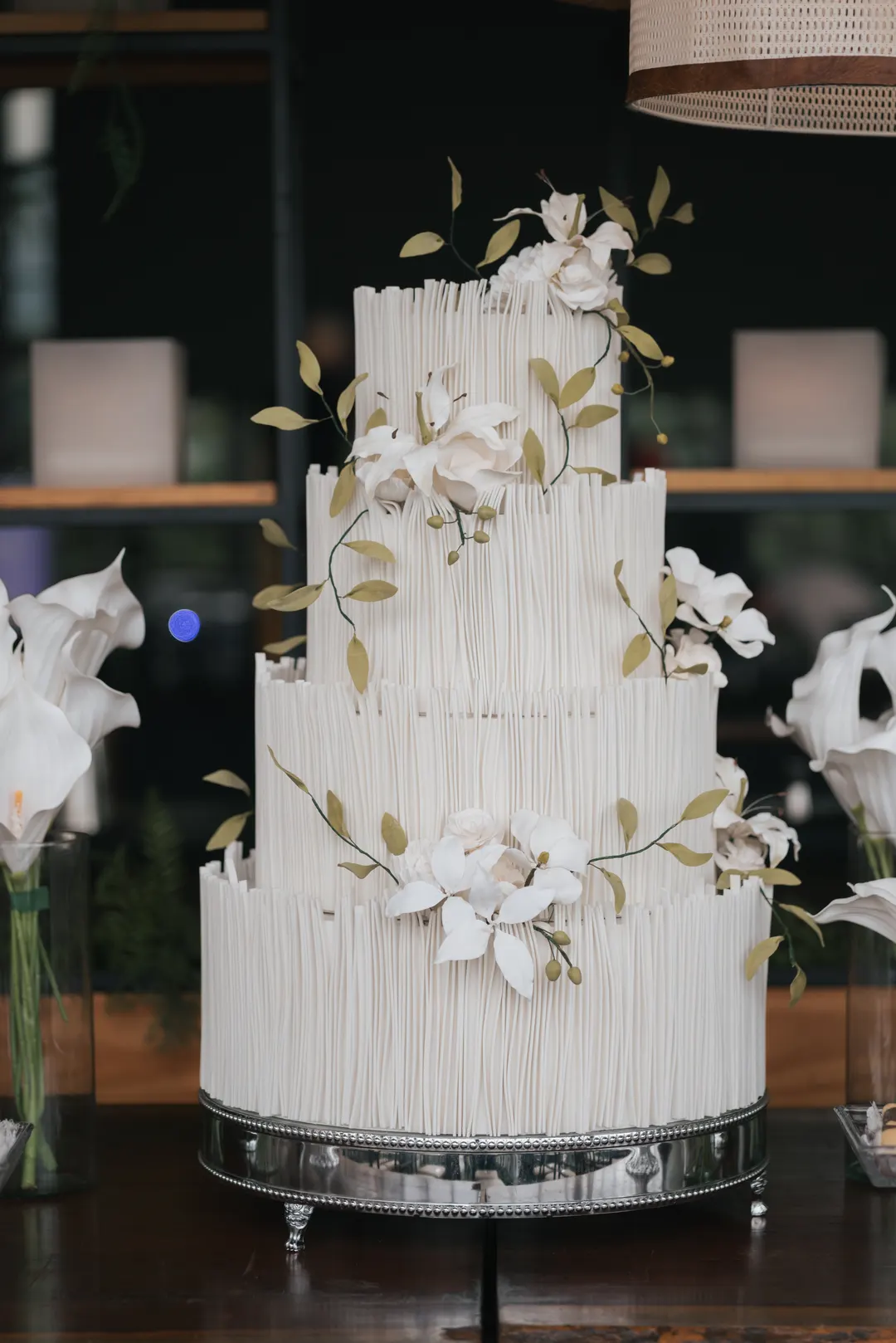 Bolo branco de quatro andares decorado com flores